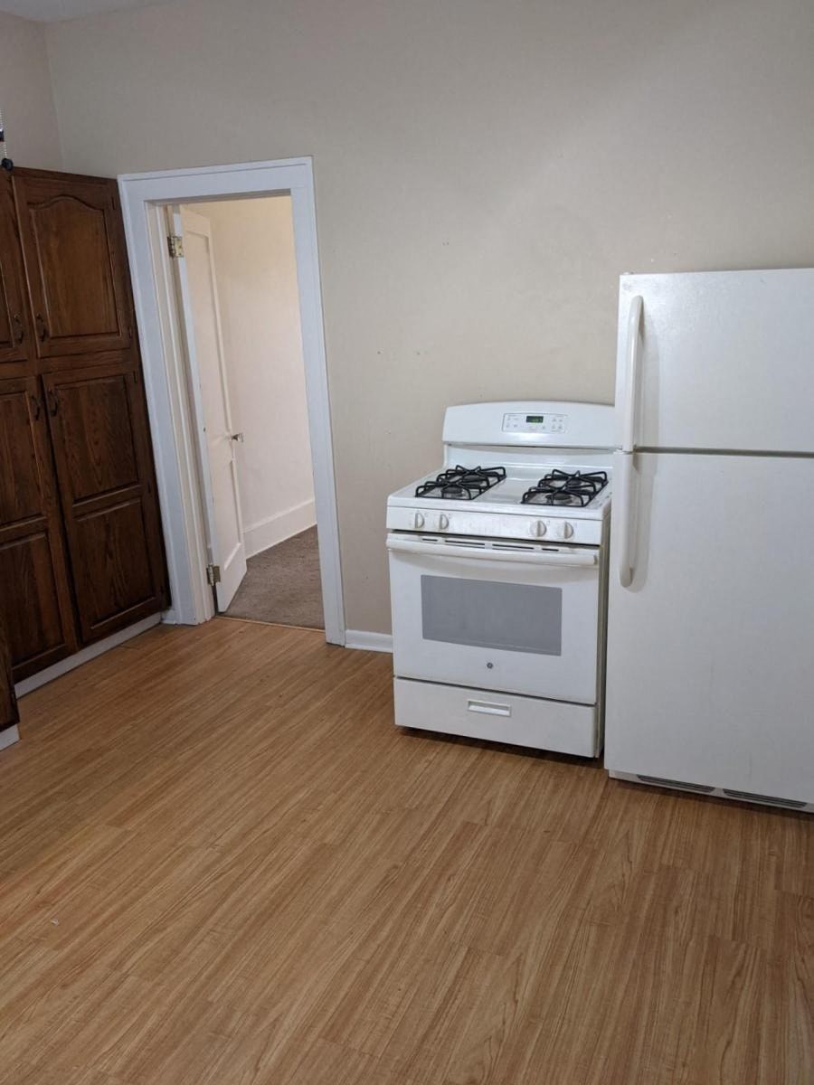 an empty kitchen with a stove and a refrigerator