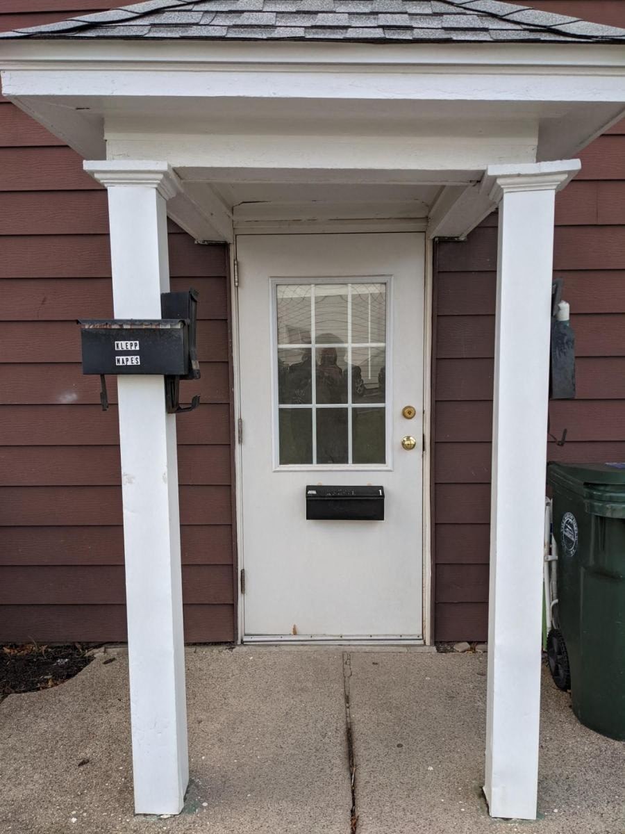 the front of a house with a white door and a mailbox