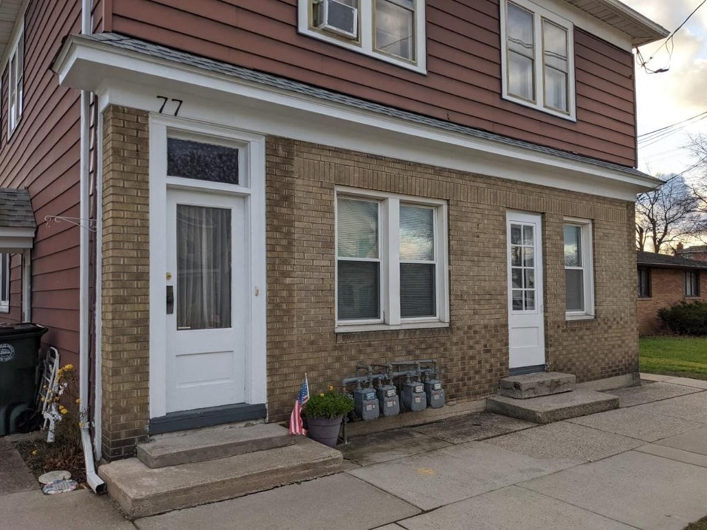 the front of a brick house with a white door
