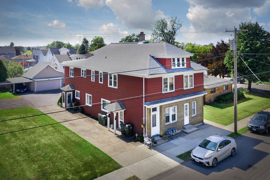 a red house with a white car parked in front of it