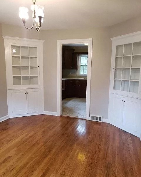 an empty living room with white cabinets and a wood floor