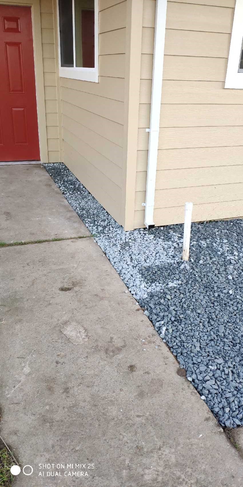 a house with gravel around it and a red door