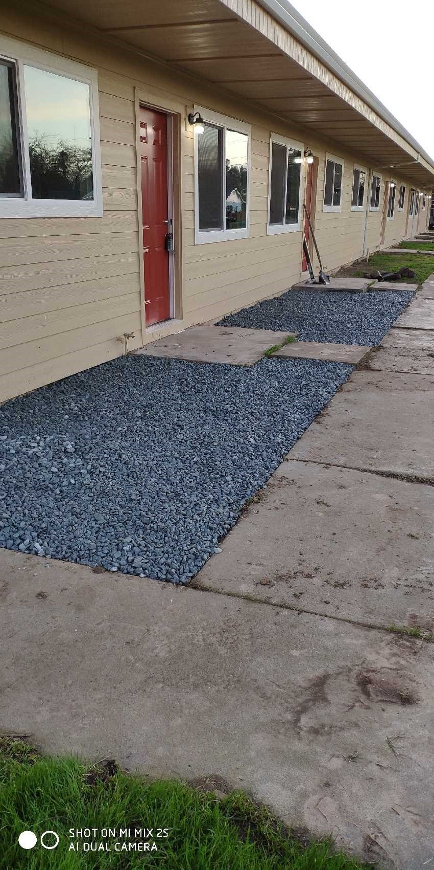a house with a sidewalk and gravel in front of it