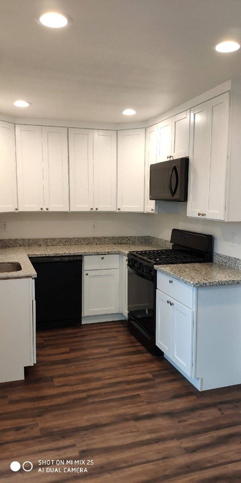 a kitchen with white cabinets and a black stove