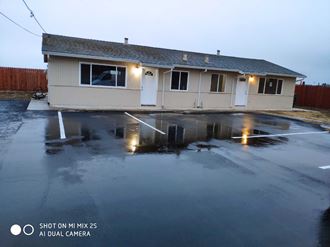 a house in a parking lot with water in the lot