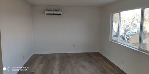 the living room of a house with wooden floors and a large window