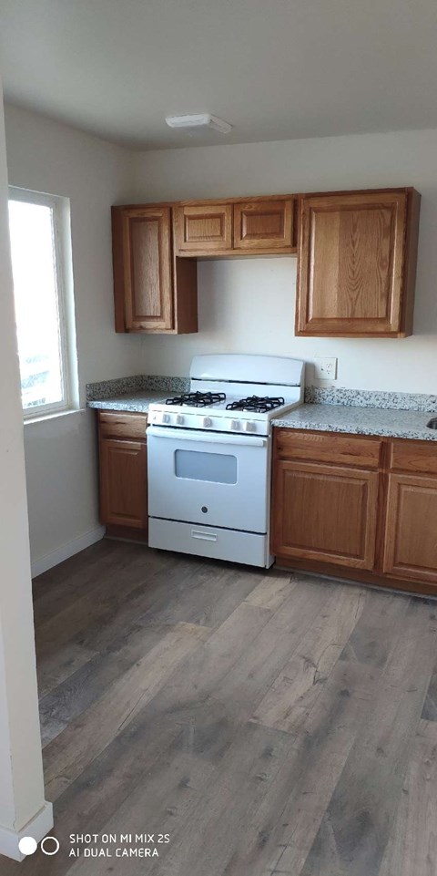 a kitchen with a white stove and wooden cabinets