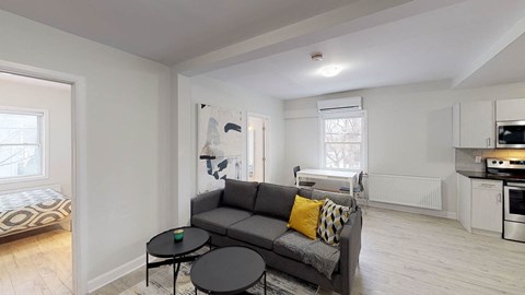 A living room with a grey couch and a black coffee table.