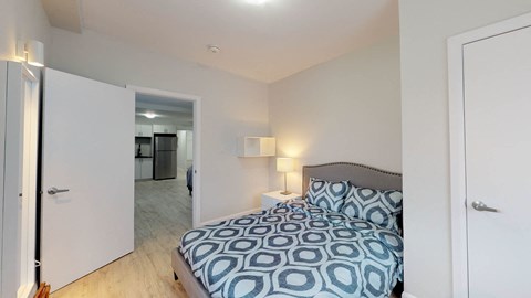 A bedroom with a bed and a mirror.