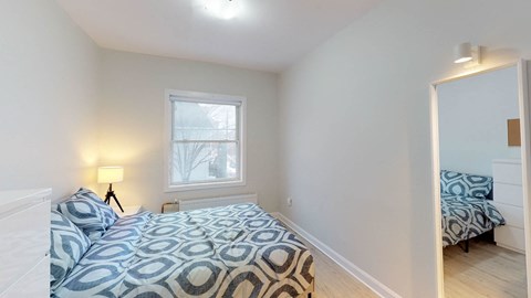 A bedroom with a bed and a window.