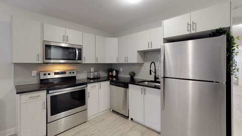 A modern kitchen with stainless steel appliances and white cabinets.
