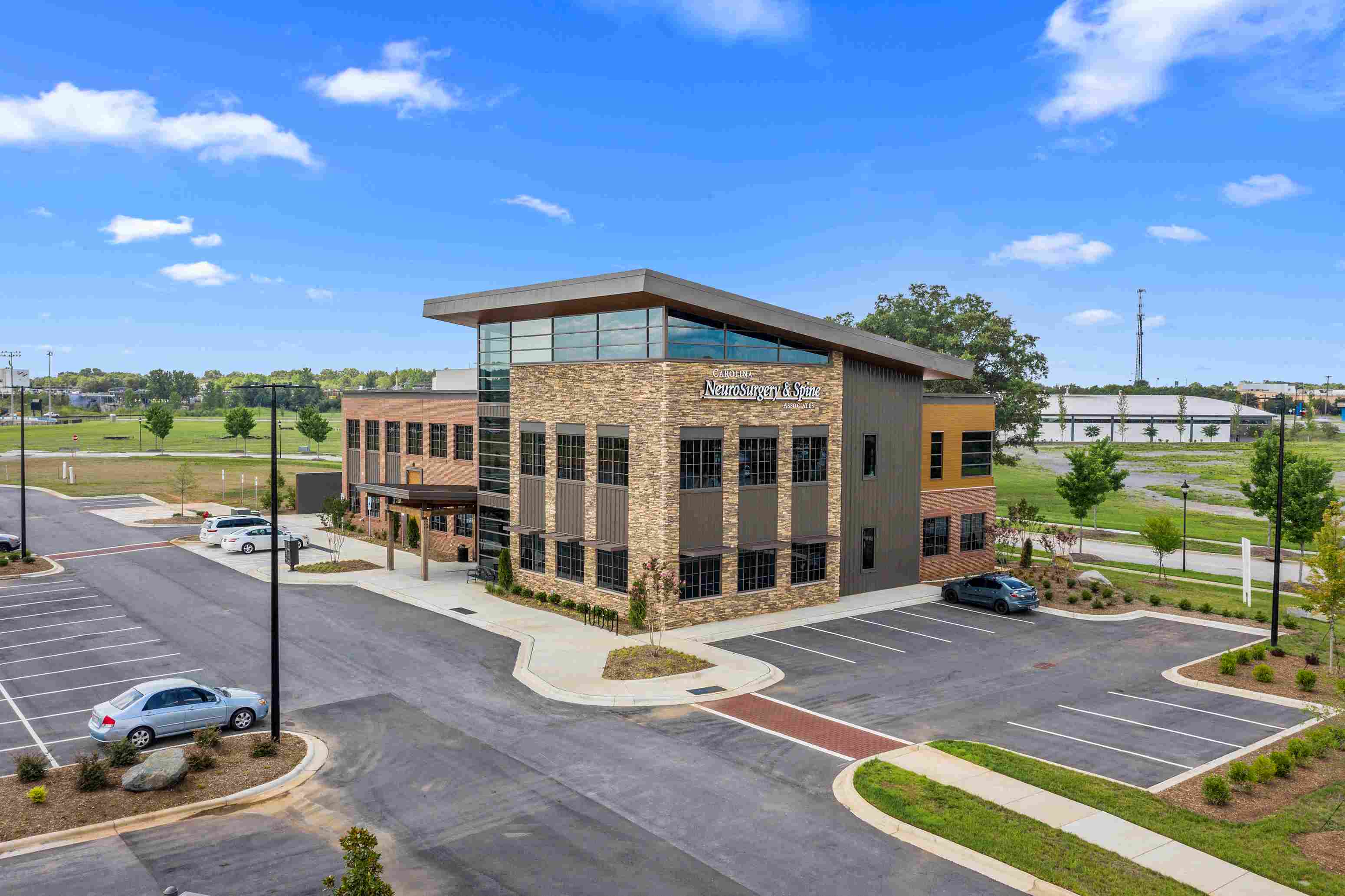 an office building with cars parked in a parking lot