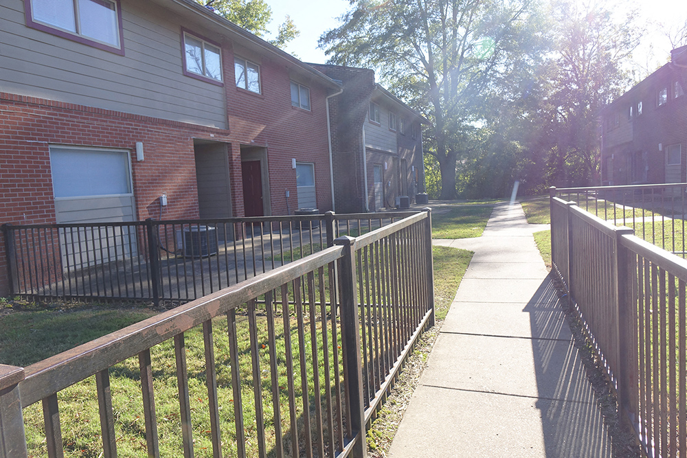 a yard with a fence in front of some houses