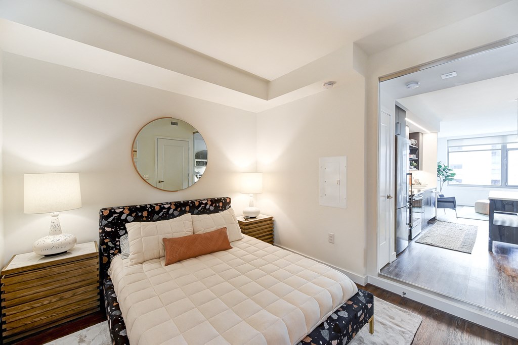 a bedroom with a large bed and a mirror