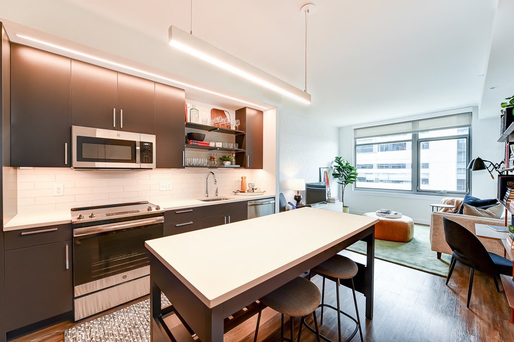 a kitchen and living room with a table and a window