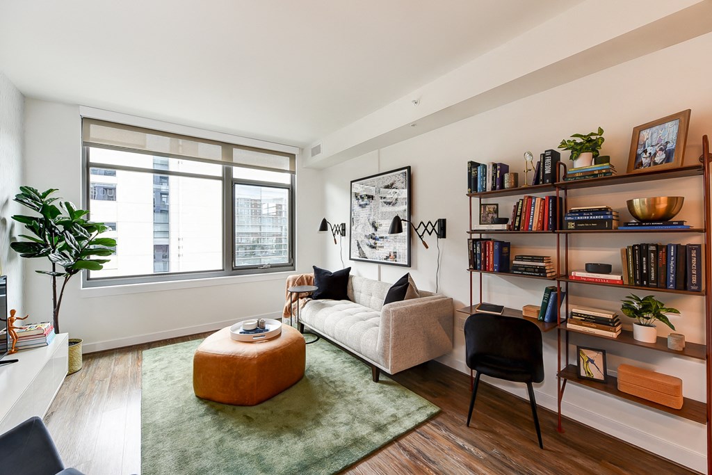 a living room with a couch and a chair and a large window
