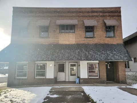 the front of a brick building in the snow