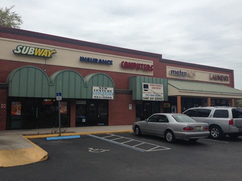 A parking lot in front of a Subway restaurant.