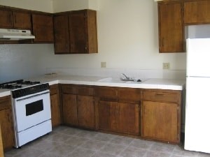 A white stove and oven in a kitchen with wooden cabinets.