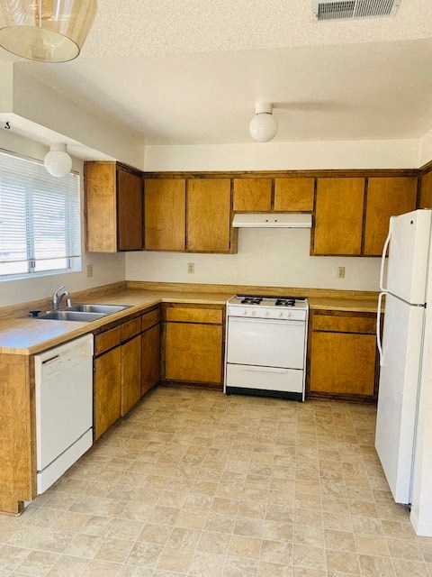 A kitchen with wooden cabinets and white appliances.