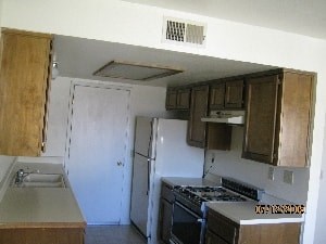 A kitchen with a stove and a refrigerator.