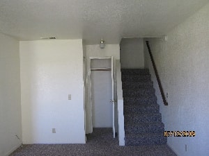 A room with a staircase and a door.
