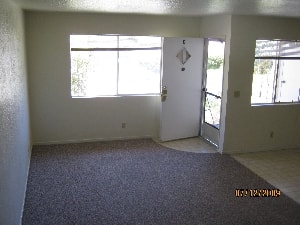 A room with a carpeted floor and a white door.