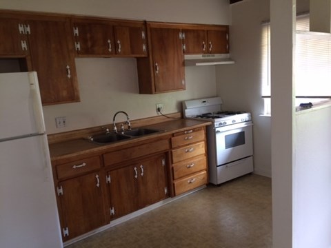 A kitchen with wooden cabinets and a white refrigerator.