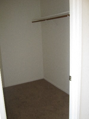 A room with a brown carpet and a white wall.
