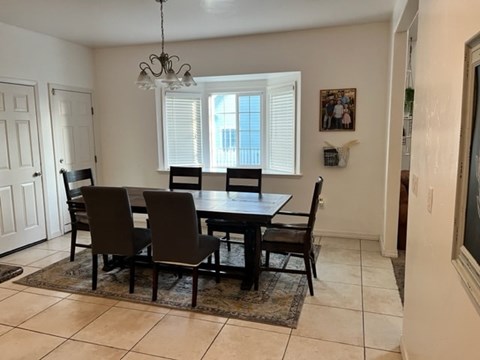 A dining room with a table and chairs.