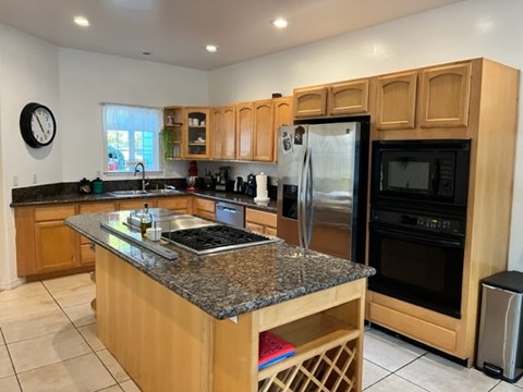 A kitchen with wooden cabinets and granite countertops.