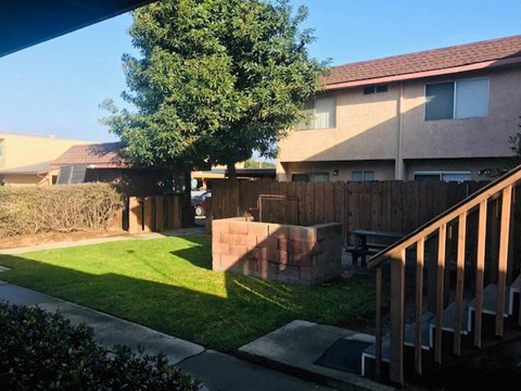 A house with a brown roof and a green lawn.