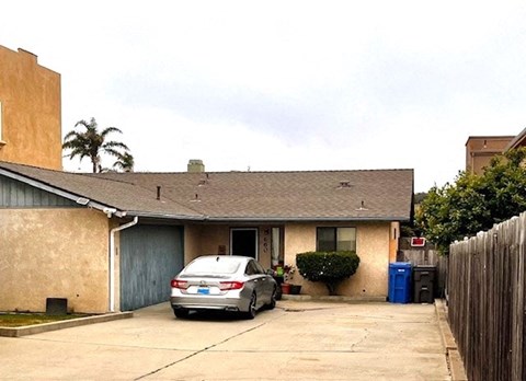 A house with a car parked in front.