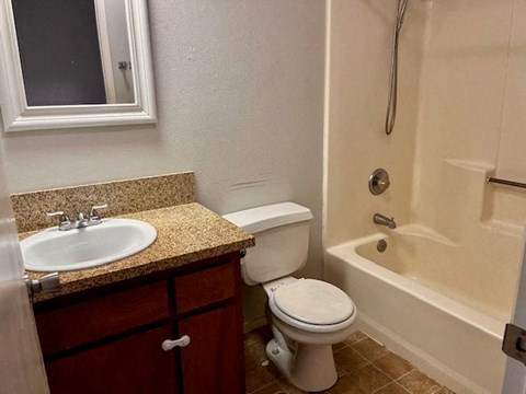 A white toilet sits next to a sink in a bathroom.