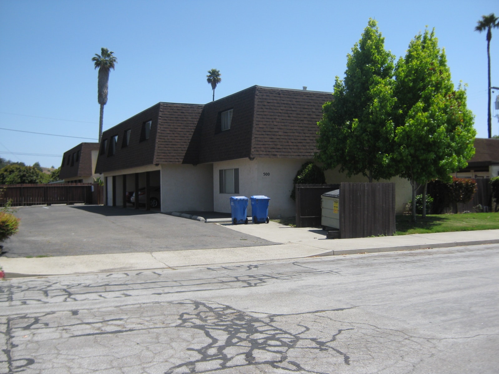 A house with a driveway and a tree in front of it.