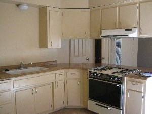 A kitchen with a stove top oven and a sink.