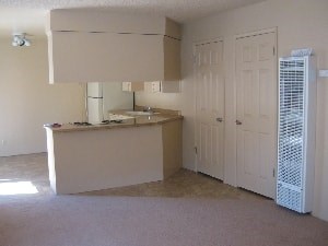 A kitchen with a white fridge and cabinets.