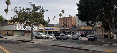 a busy city street with cars parked in front of stores