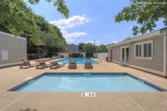 a swimming pool with chairs and a house