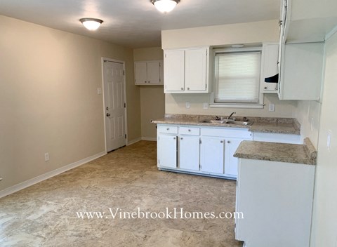 A kitchen with white cabinets and a countertop.