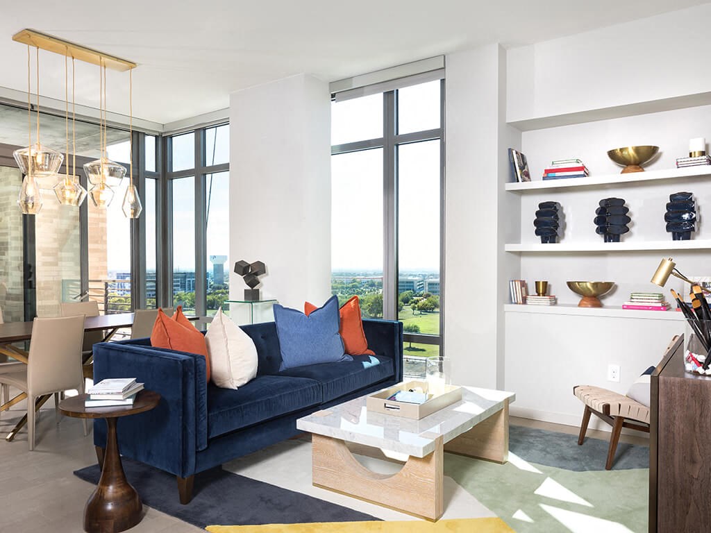 a living room with a blue couch and a large window