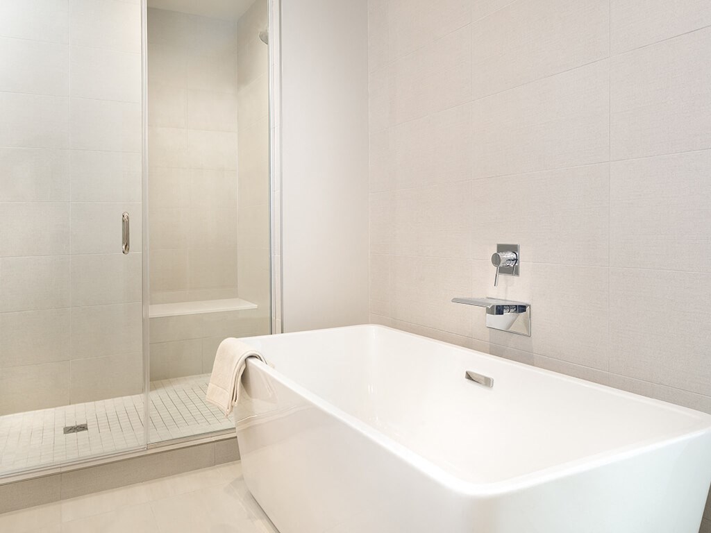 a white bathroom with a tub and a shower
