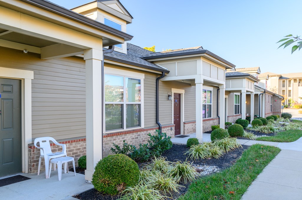 a row of houses with a white chair in front of a sidewalk