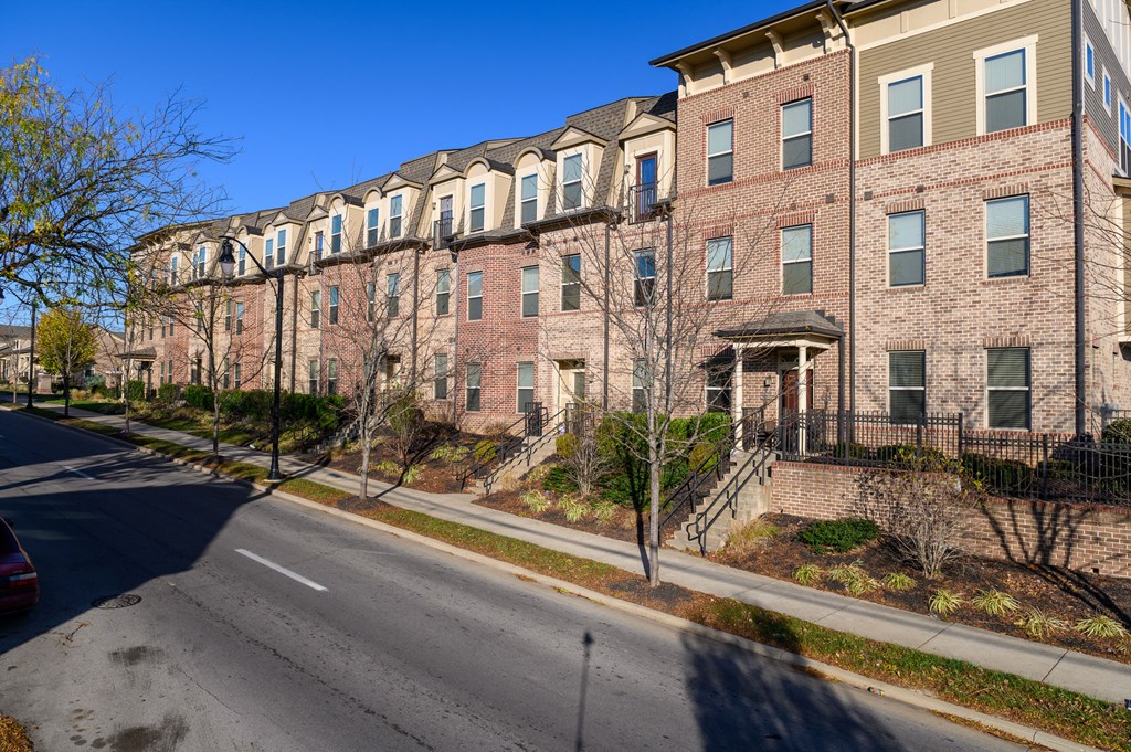 a row of brick apartment buildings on the side of a street