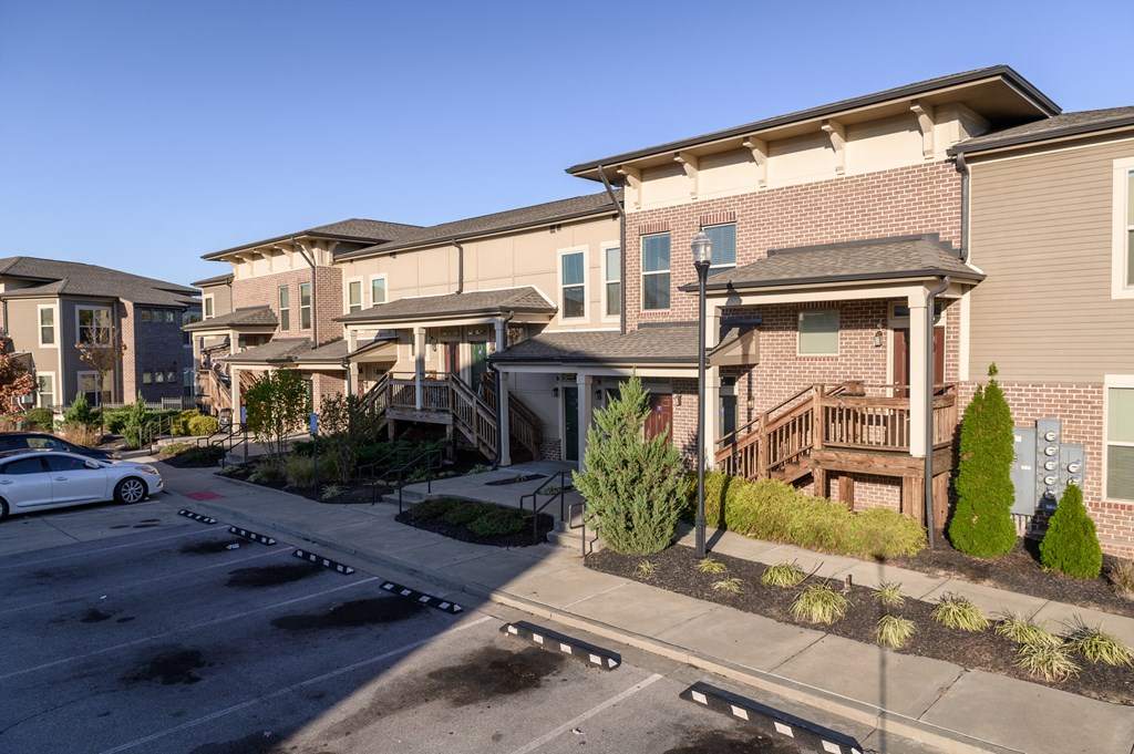 a row of apartment buildings with balconies and a parking lot