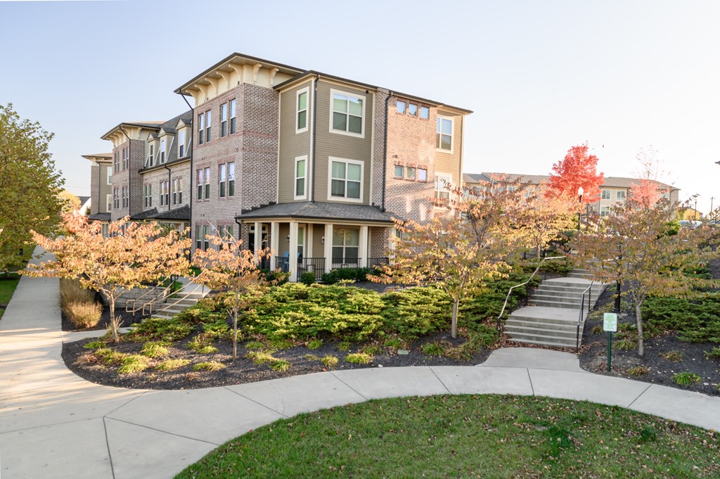 a building with stairs and trees in front of it