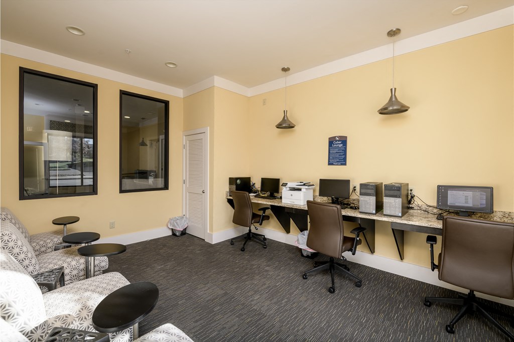 a break room with computers and chairs and a couch
