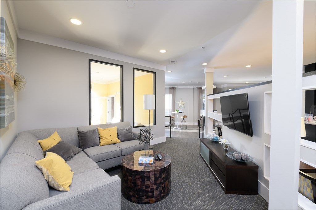 a living room with a gray couch and a television