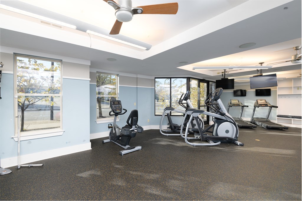 a gym with exercise machines and a ceiling fan