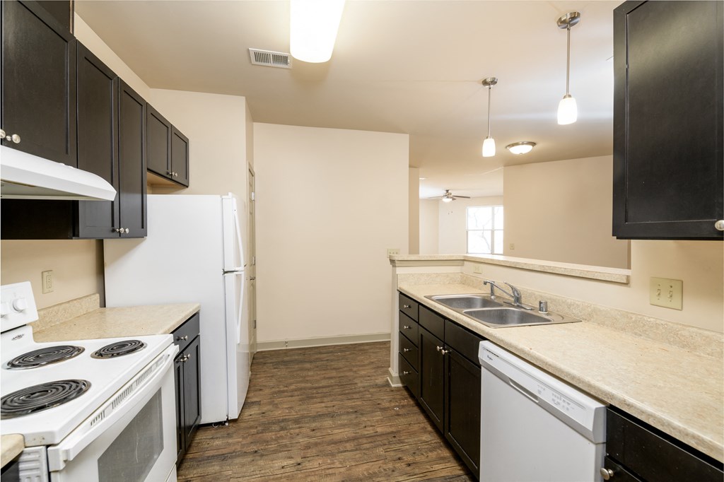 an empty kitchen with white appliances and black and white cabinets